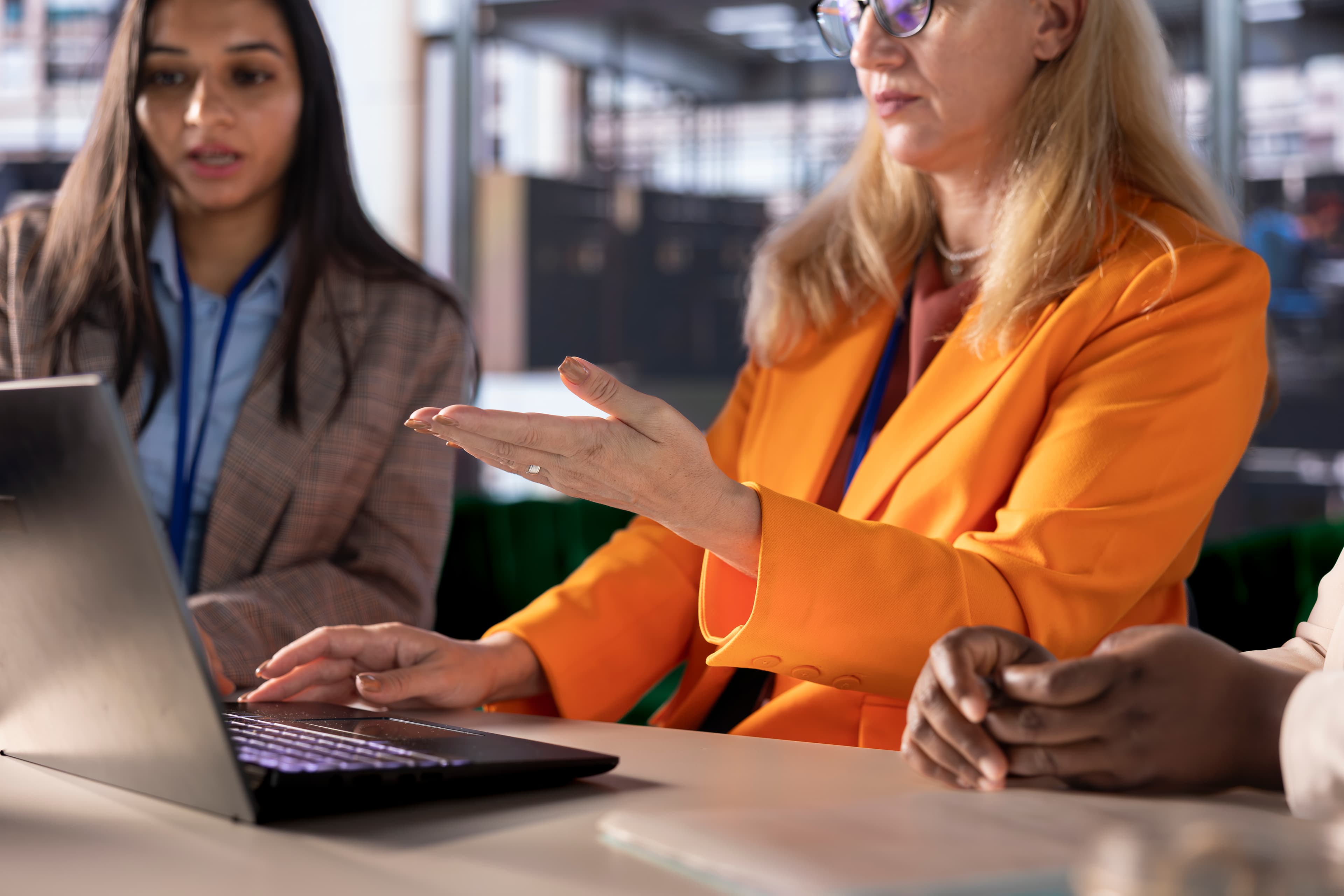 Teamleder som viser kollegaer et nytt verktøy på en skjerm